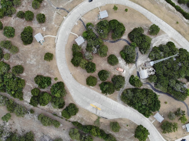A drone's-eye view of a revitalized green space where an old industrial site once stood, with new trees and walking paths, symbolizing environmental cleanup and community development.