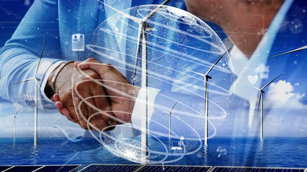Close-up of hands shaking over a blueprint, with digital overlays of renewable energy graphs and global maps, symbolizing collaboration, policy agreements, and the collective effort towards a sustainable energy future.