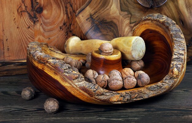 A rustic wooden bowl filled with an assortment of fresh, earthy mushrooms including shiitake, maitake, and cremini, suggesting variety and natural sourcing.