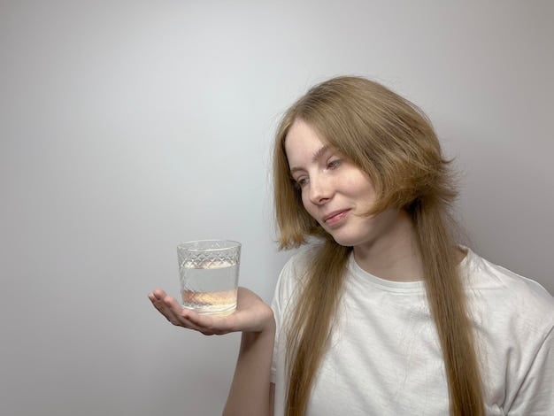 A person holding a clear glass of water next to a multivitamin, symbolizing proper hydration and supplement intake.