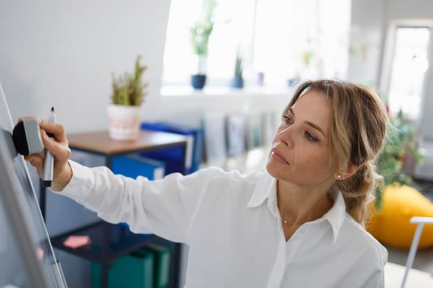 A person demonstrates a conscious posture check, gently drawing their shoulders back and down, with an alert and mindful expression, in a brightly lit office setting.