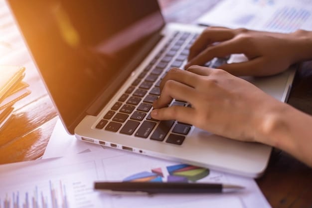 A close-up of hands filling out a FAFSA form on a laptop, surrounded by financial documents, indicating the detailed and crucial nature of the application process.